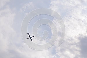 Blue sky with white clouds and a flying plane. View from the top