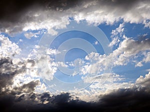 Blue sky and white clouds framed by dark thunderclouds after a thunderstorm. Dramatic impressive illustration. Bright future and