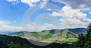 The blue sky, white clouds, green mountains and grass ring around the beautiful village