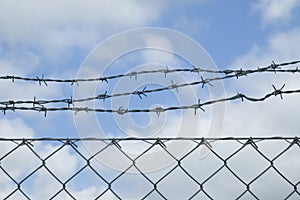 Mesh wire fence with barbwire on top photo