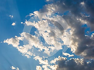 Blue sky with white clouds and some dark clouds approaching.