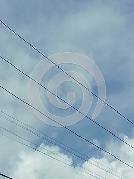 blue sky with white clouds stretched by electric cables