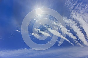 Blue sky, white clouds and sun with halo