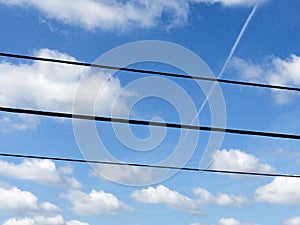 Blue sky white clounds with power lines on sunny day jet stream