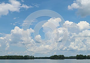 Blue sky with white puffy clouds over a fresh water lake