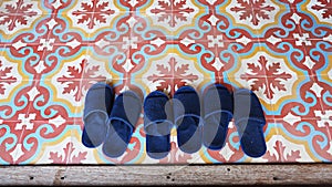 Blue slippers on vintage asian art floor tiles.