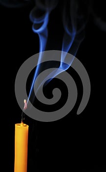 Extinguished candle with smoke close-up on a dark background