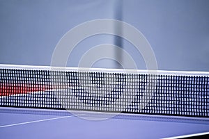 Blue and smooth surface table tennis table with tight black net to being prepared for practice and competition