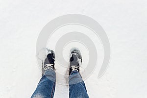 Blue sneakers on snow. A look from above.