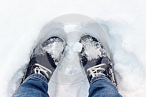 Blue sneakers on snow. A look from above.