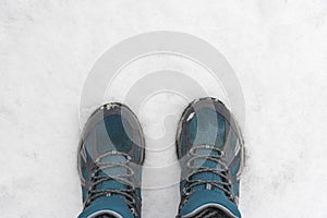 Blue sneakers on snow. A look from above. Sport shoes top view