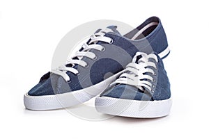 Blue sneakers on white background with copy space. Youth shoes