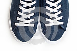 Blue sneakers with white toe and white laces on a white background with copy space
