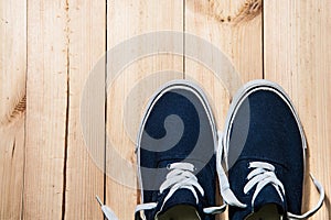 Blue sneakers on wooden background with copy space. Top view.