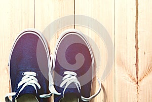 Blue sneakers on wooden background with copy space. Top view.