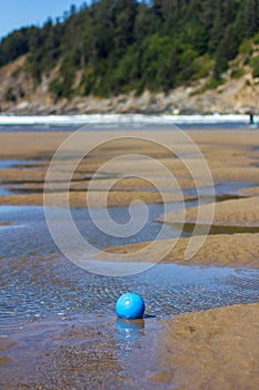 Blue soccer ball in a tide pool