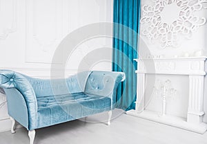 Blue sofa in white interior and gray floor. Venetian style. Decorative fireplace