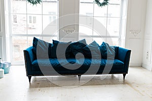 Blue sofa in white simple living room. Modern color of blue velvet couch