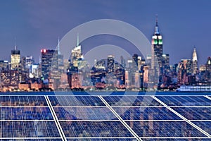 Blue solar cell panels, New York skyline illuminated at night