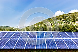 Blue solar collectors near town on mountain photo