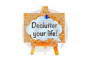 Blue speech bubble with phrase Declutter Your Life on corkboard