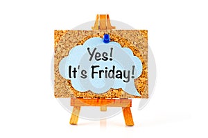 Blue speech bubble with phrase Yes! It`s Friday! on corkboard on