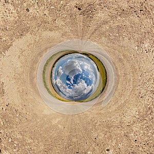 blue sphere little planet inside gravel road or field background. curvature of space