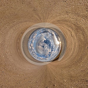 blue sphere little planet inside gravel road or field background. curvature of space