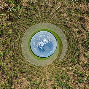 Blue sphere little planet inside green grass field background. curvature of space