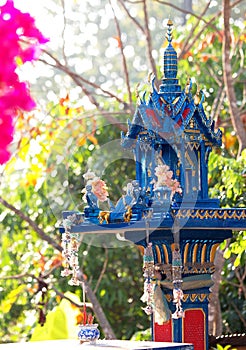 Blue spirit house in thailand with flower vases