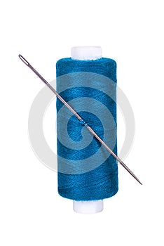 Blue spool of thread with a sewing needle on a white isolated background