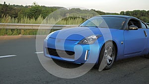 Blue sport car driving on the city highway