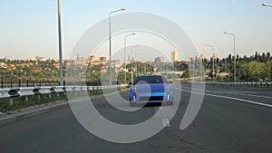 Blue sport car driving on the city highway