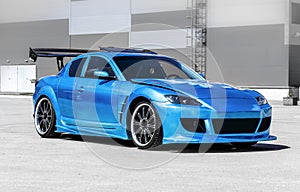 Blue sport car on race way. Closeup capture.