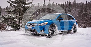 Blue sport Utility vehicle into snowfall