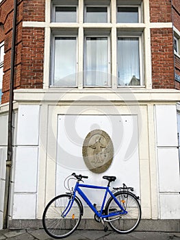 Blue sports bicycle under the street wall blazon of Manufacture trade association