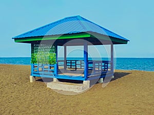 Blue square gazebo with seascape on sandy beach