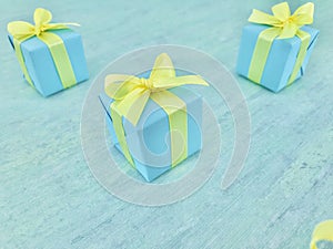 Blue square gift boxes placed diagonally on a blue-green watercolor textured background