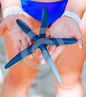 Blue starfish holding in woman hand, Blue starfish found on the white coral sand beach in boracay Philippines. ocean coast