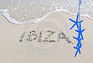 Ibiza written in sand