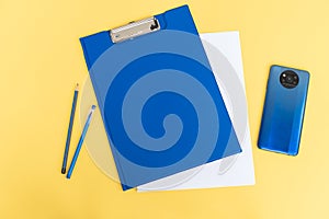 A blue stationery set as a template with a place to copy on a yellow background with a phone