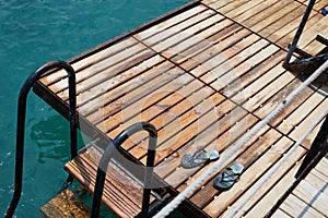 Blue step-ins on the wooden sea pier stairs photo