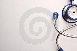 Blue stethoscope on white table close up