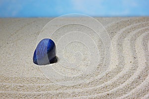 Blue stone in the sand for meditation, concentration and concentration.  The concept of balance, harmony and purity of