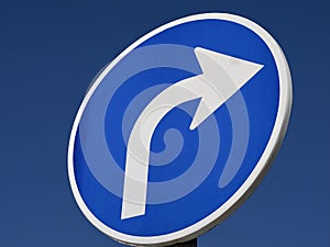 Blue street sign turn right with a white arrow