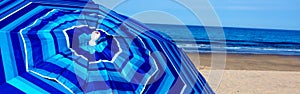 Blue striped beach umbrella at Wellfleet MA on Cape Cod photo