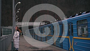 The blue subway train leaves the ground station on the bridge across the wide Dnieper River in Kiev.