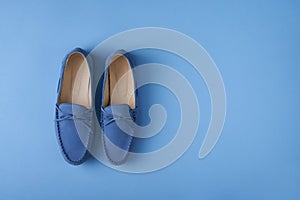 Blue suede man`s mocassin shoes over blue background