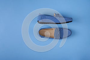 Blue suede man`s mocassin shoes over blue background