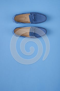 Blue suede man`s mocassin shoes over blue background